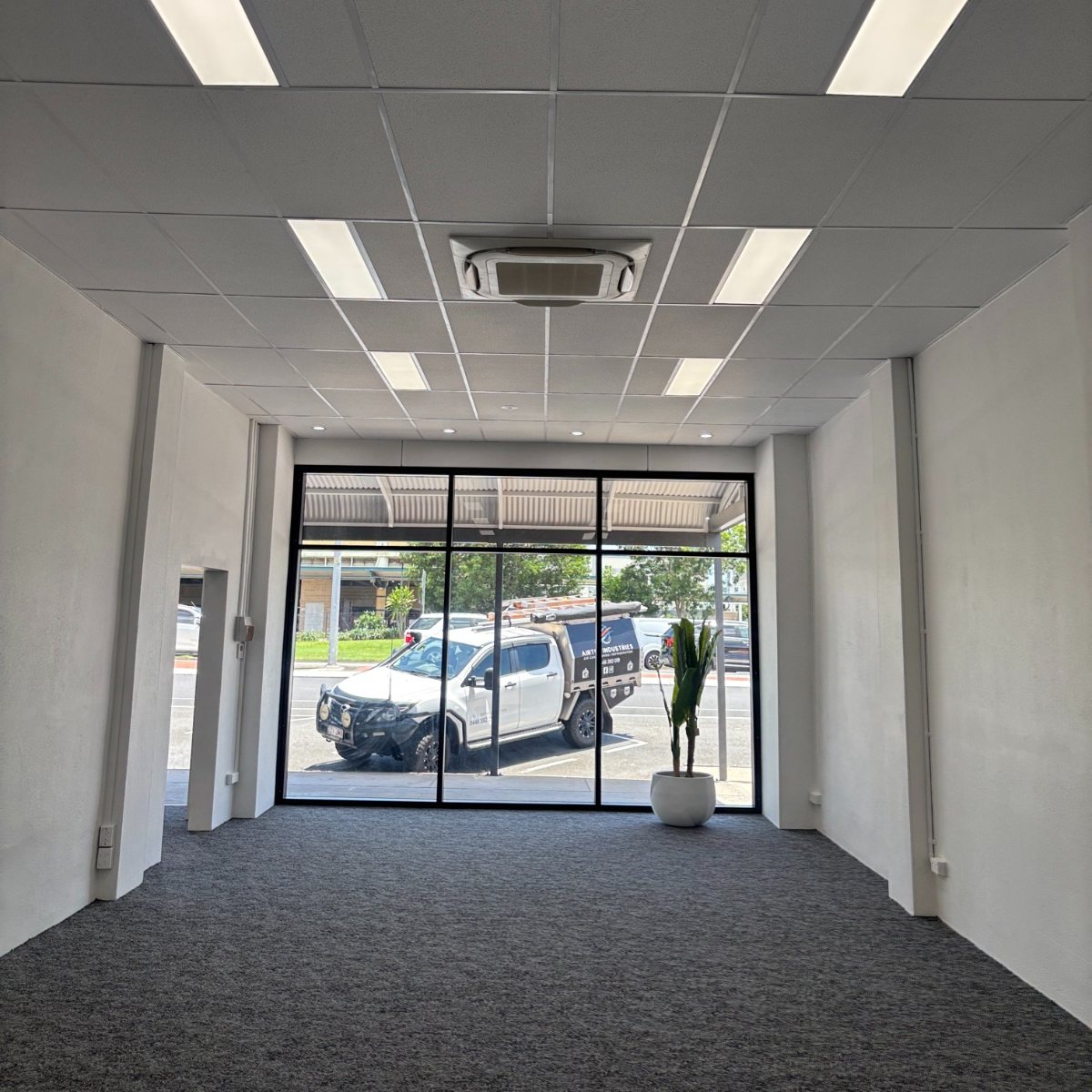 Compact 600x600 ceiling cassette fitted into a suspended ceiling grid in a Cairns office