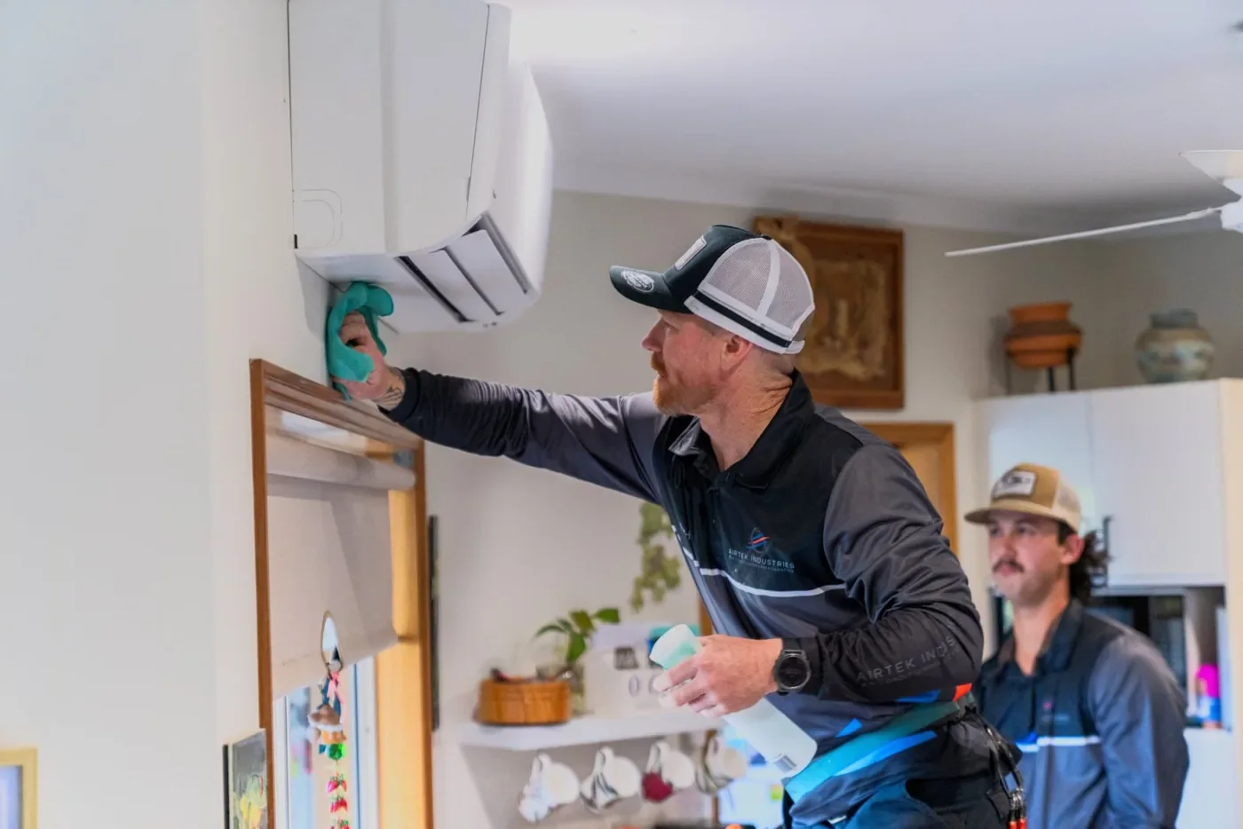 Airtek technician servicing a split system indoor unit in a Cairns home